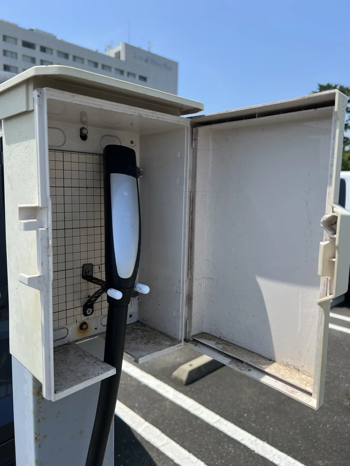 南京錠付きボックスを開けて取り出したテスラの充電コネクター